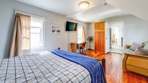 Ein Schlafzimmer mit Bett, Schreibtisch, Stuhl und Kleiderschrank.