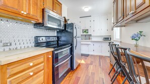 A kitchen with wooden cabinets, a microwave, a refrigerator, and a double oven. - 1/2 Mi to Ocean: Cozy Apt in Old Orchard Beach (Old Orchard Beach)