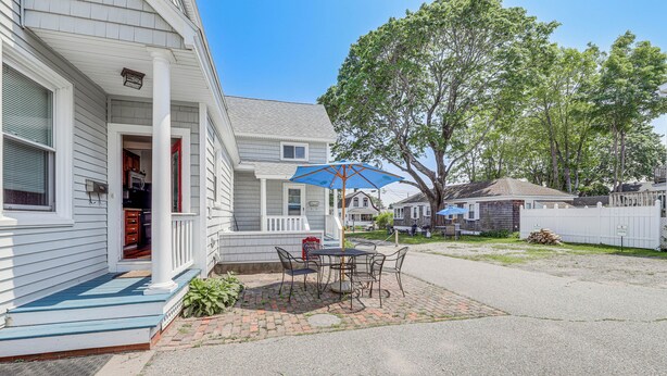 A residential house with a porch, a dining table with chairs, and a blue umbrella. - 1/2 Mi to Ocean: Cozy Apt in Old Orchard Beach (Old Orchard Beach)