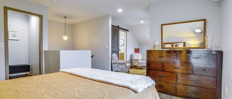 Une chambre à coucher avec un lit, une commode et un miroir.