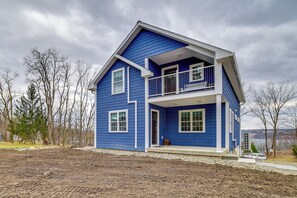 A two-story blue house with a balcony, a front porch, and a driveway. - Seneca Lake Wine Trail Studio w/ Balcony & Views! (Hector)
