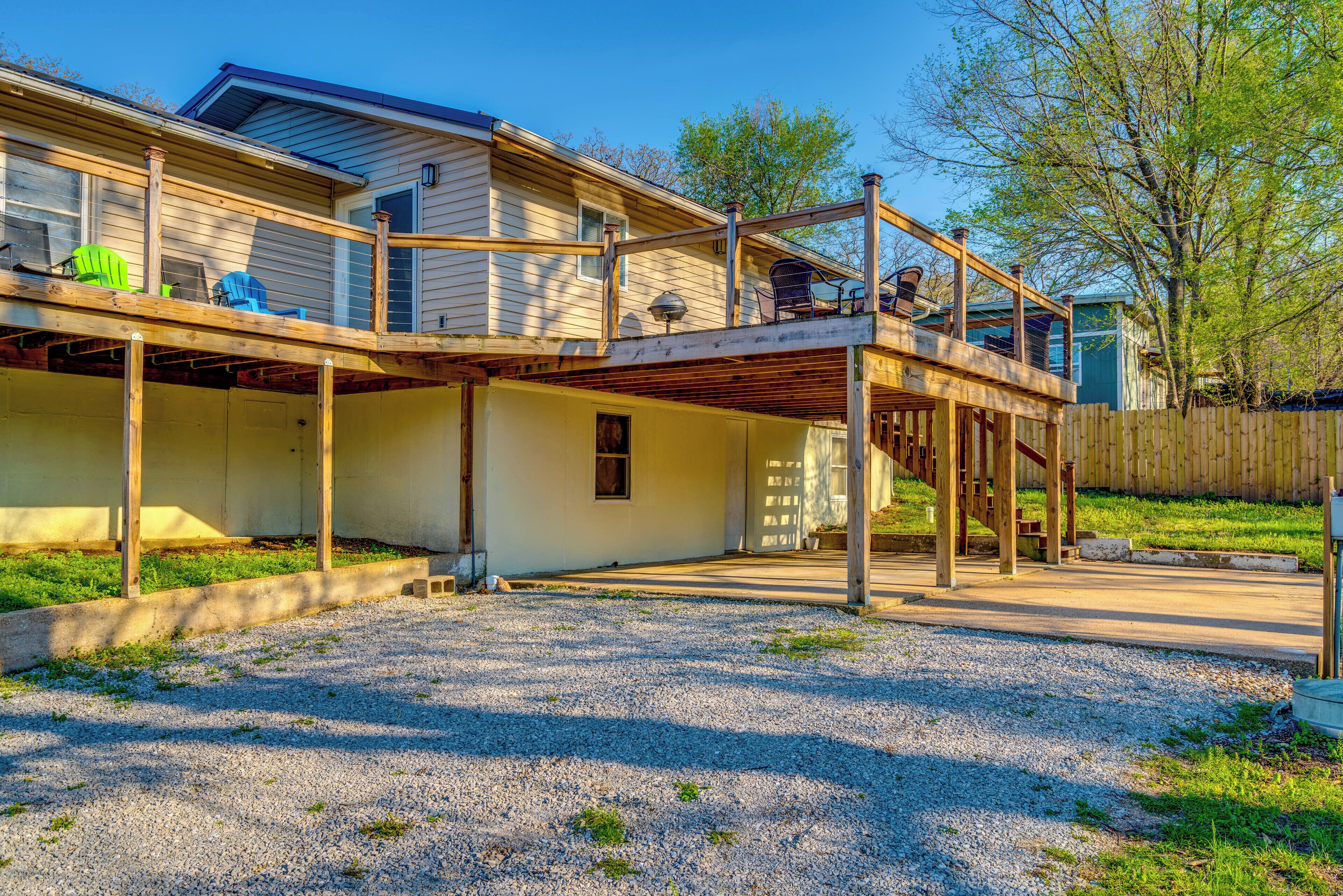 A two-story house with a covered patio, a wooden deck, and a fenced yard.