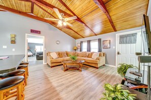 A spacious living area with a wooden ceiling, a large sofa, a coffee table, and a dining area with bar stools. - < 1/2 Mi to Marina: Missouri Lake Getaway (Warsaw)