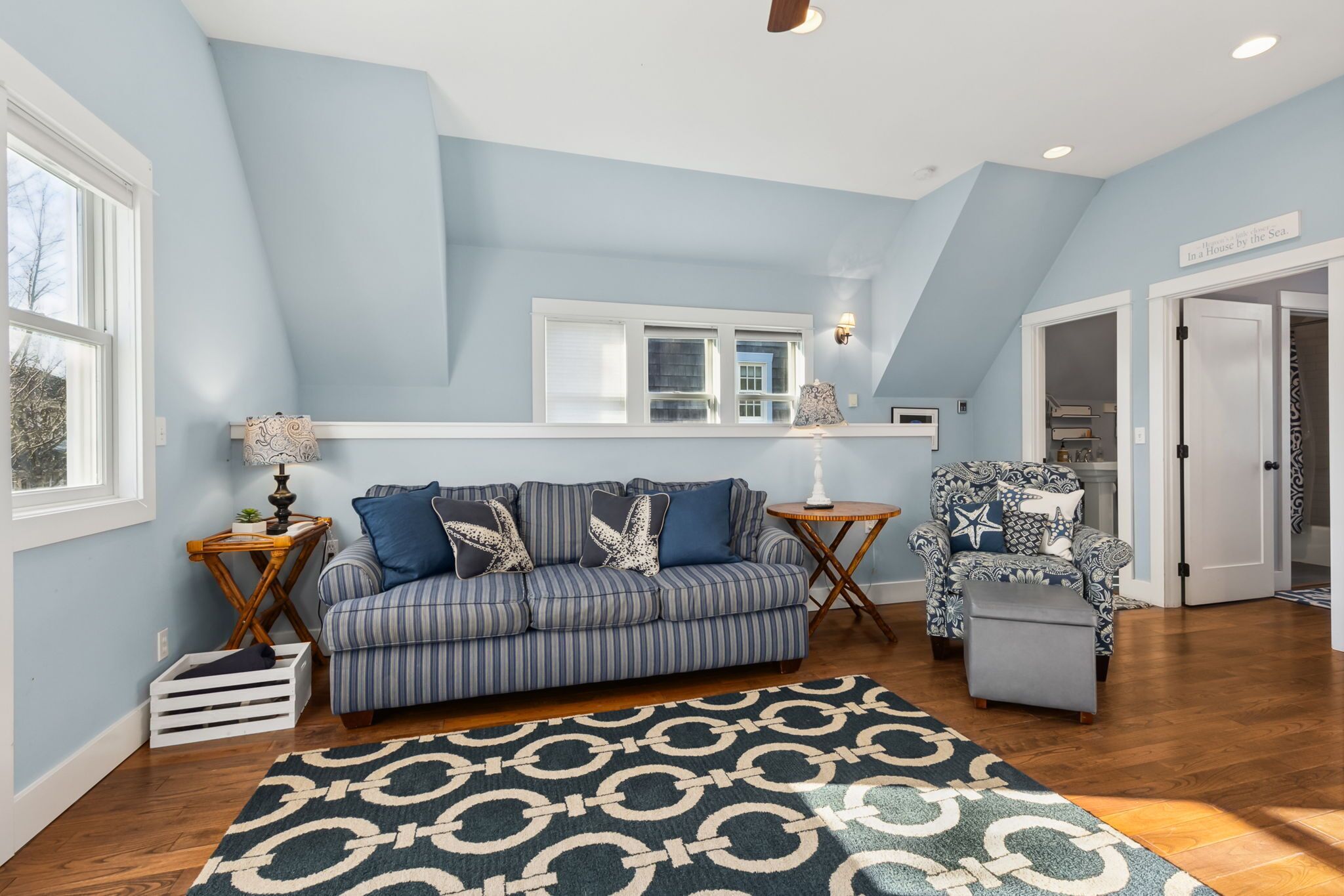 A living room with a blue sofa, patterned rug, and a star-patterned armchair.