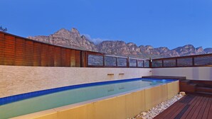 Une piscine dotée d’une terrasse en bois et offrant une vue sur les montagnes.