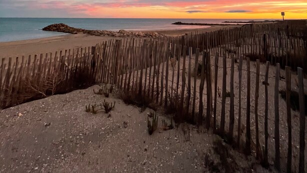 A beach with a wooden fence and a rocky outcrop. - Maison Front de Mer Aresquiers | Direct beach access | 4 bedrooms (Frontignan)