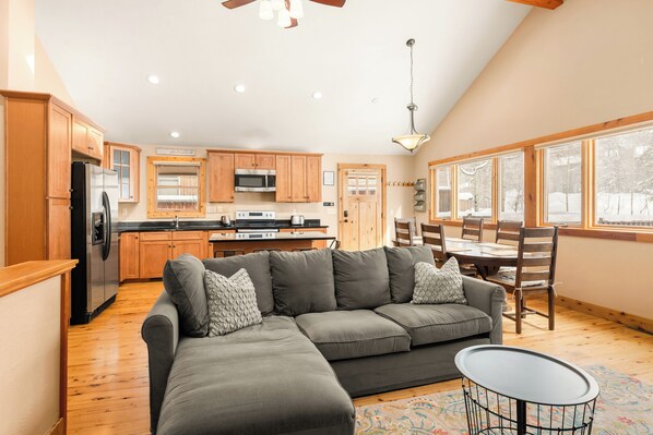A spacious kitchen with wooden cabinets, a refrigerator, and a dining area with a table and chairs.