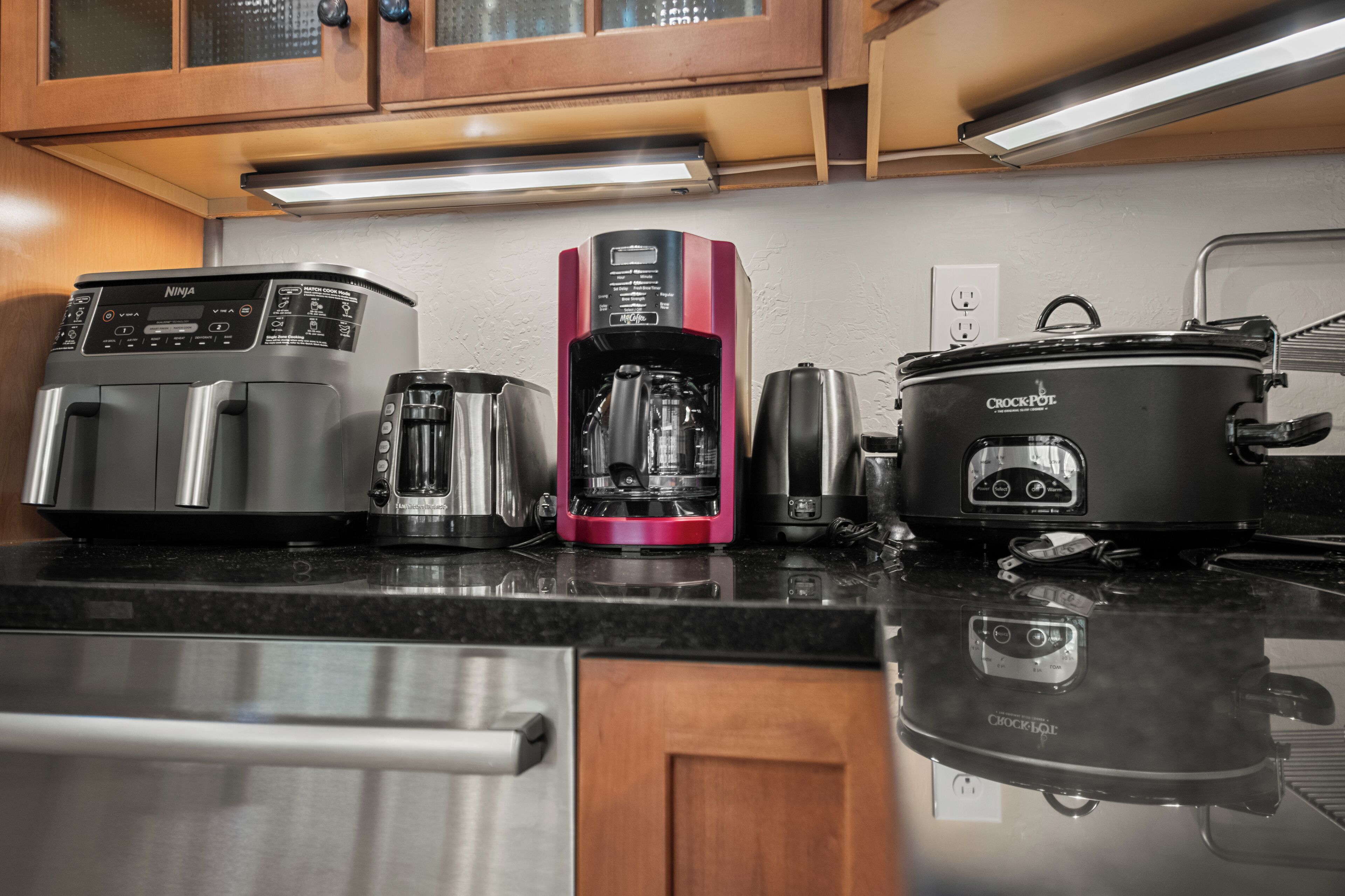 A kitchen with a coffee maker, toaster, and crockpot.