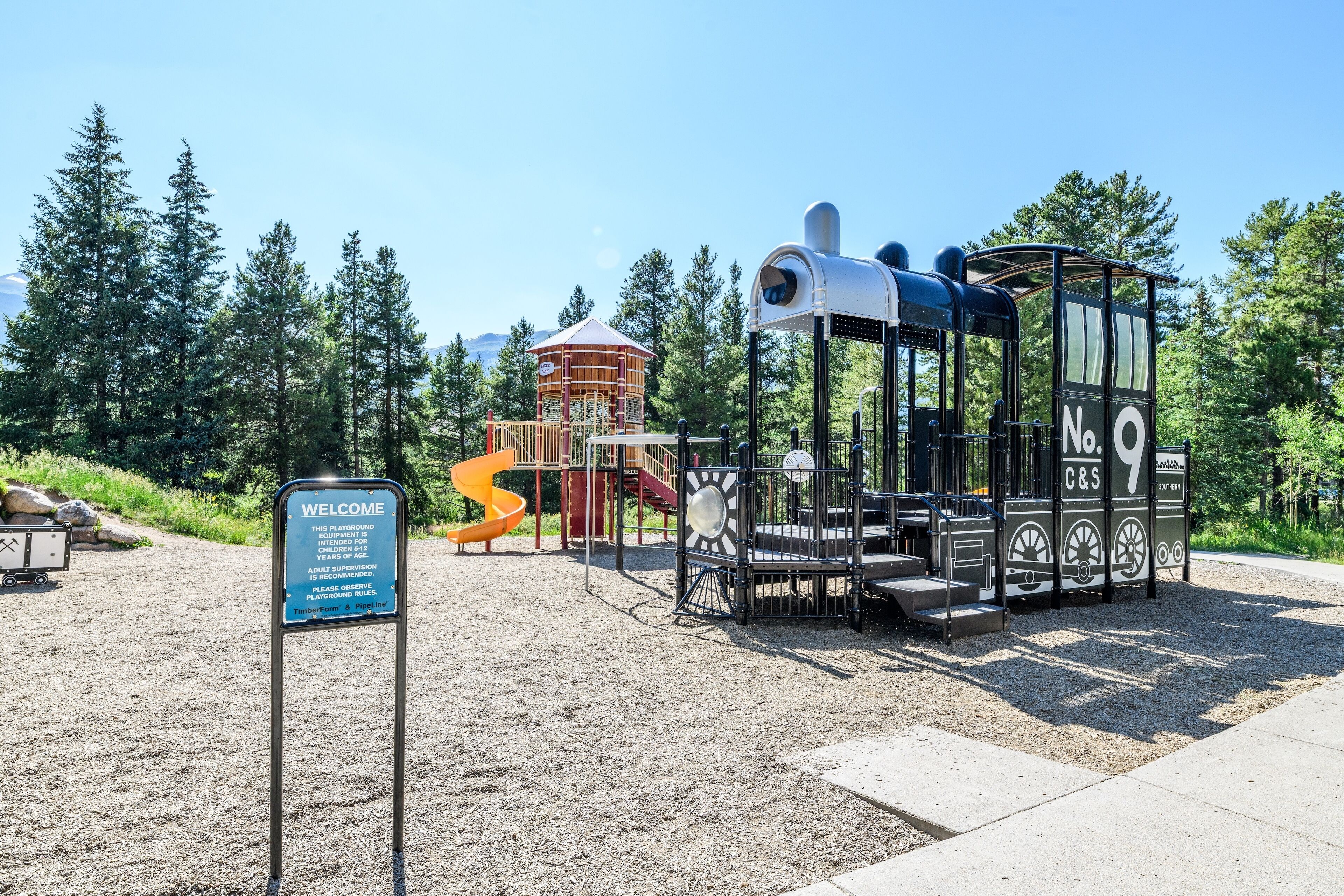 A playground with a slide, climbing structures, and a lookout tower.
