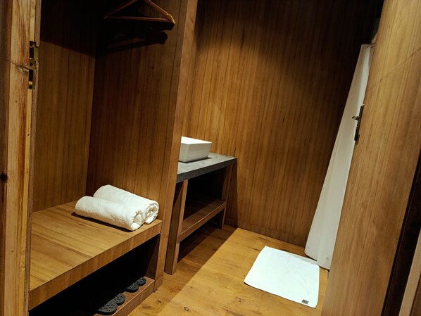A wooden room with a bench, a shelf, and a door. - The Himalayan Tyangboche (Lukla)