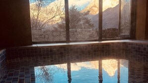 A swimming pool with a clear view of a mountain range through large windows. -  The Himalayan Tyangboche (Lukla)