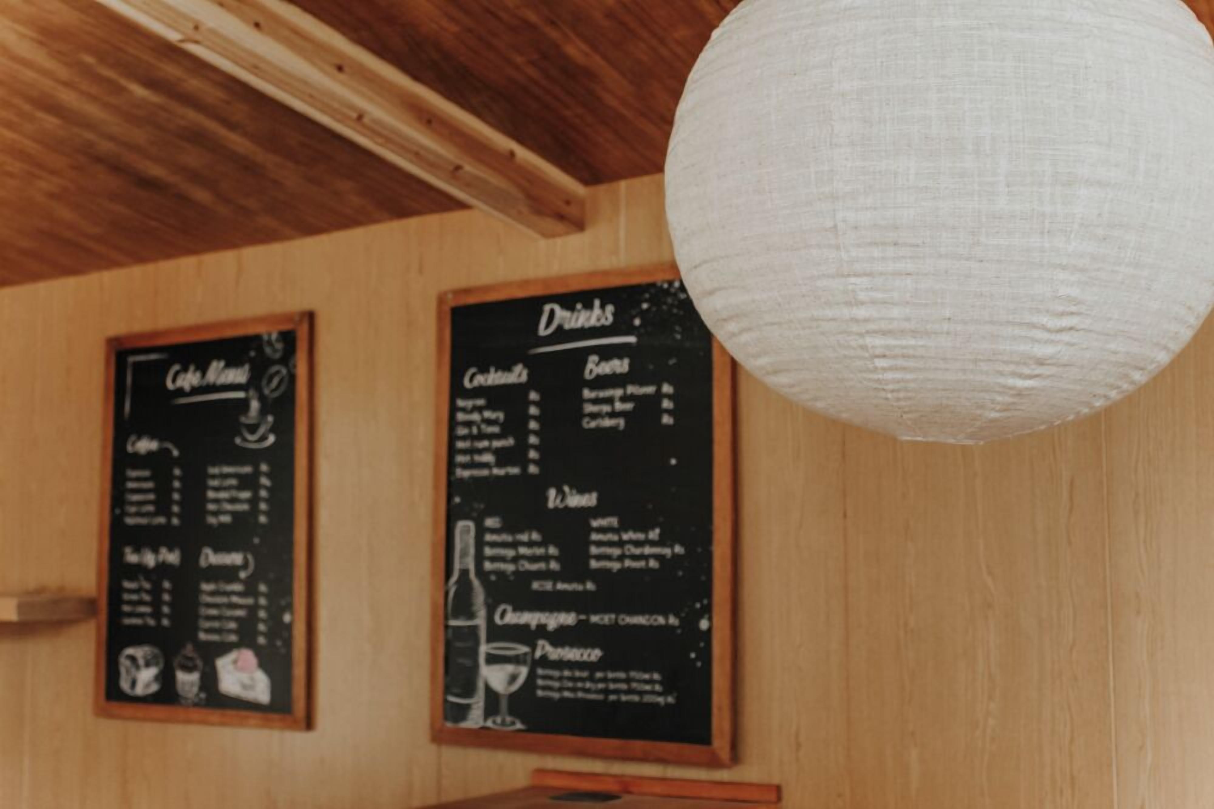 Tablero de menú con opciones de bebidas y comida en un interior de madera.