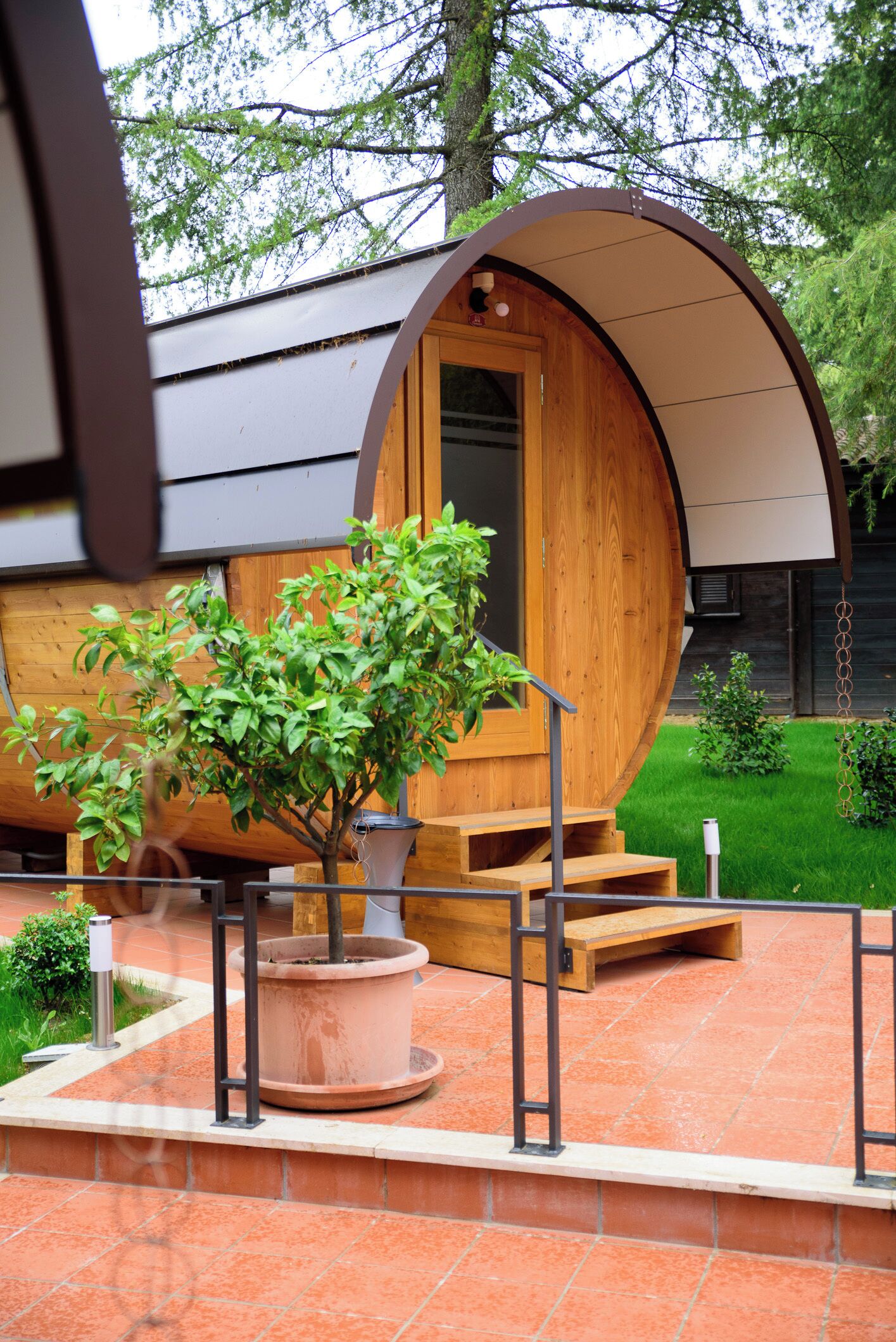 A wooden structure with a curved roof, a door, and a small set of stairs leading up to it.