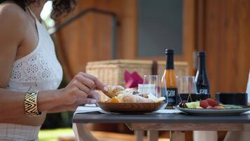 Una persona sentada a una mesa con un plato de comida, una botella y un vaso.
