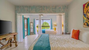 Una habitación de hotel con cama, televisión, mesa y vistas al exterior.