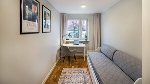 Une petite pièce comprenant un lit, un bureau et une fenêtre.