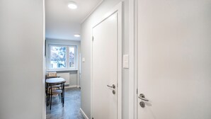Un couloir comprenant un coin repas, une fenêtre et deux portes.