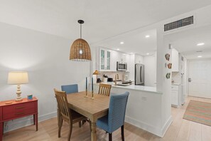 A modern kitchen with white cabinets, a microwave, and a refrigerator.
