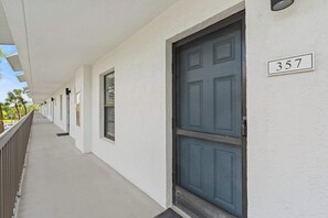 Ein Gebäude mit weißer Fassade, einer blauen Tür und einem Schild mit der Nummer 357.
