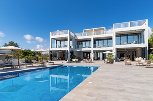 Ein modernes Hotel mit Schwimmbad, Außenbereich zum Sitzen und mehreren Balkonen.