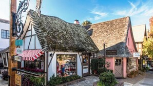 A traditional building with a thatched roof and a shop front with a red and white striped awning. - 3972 DolceVita ~Beautiful Remodel, Walk Everywhere (Carmel)
