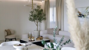A modern living room with a marble coffee table, a sofa, and a potted plant.