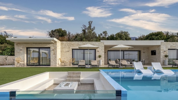 A modern pool area with lounge chairs and a glass-enclosed hot tub.