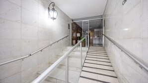 A modern hotel interior with marble walls, a staircase with metal railings, and a sign reading "CHAT." - Rj04 Ap em Copacabana até 6 pessoas (Rio de Janeiro)