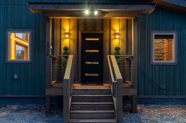 A wooden building with a dark entrance, two side lights, and a number '2736' on the wall. - Reflections 1 Bedroom Cabin (Sevierville)