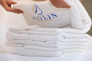 Una pila de toallas dobladas con un logotipo y texto que indican que son del Hotel Boutique Daylin.