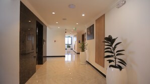 A modern hotel lobby with a polished marble floor, a reception desk, and potted plants. - Daylin Guest House (Addis Ababa)