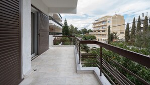 A balcony with a view of neighboring buildings and trees. - LIV - Seaside Getaway in Glyfada (Glyfada)
