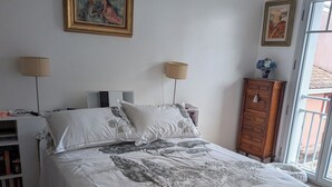 A bedroom with a bed, two bedside lamps, a dresser, and a window. - Appartement au coeur dándernos les Bains (Andernos-les-Bains)