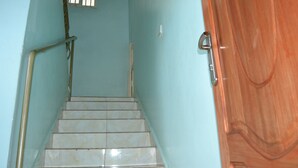 Un escalier avec une rampe métallique menant à une porte en bois.