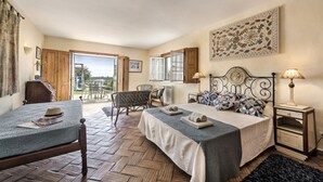 A bedroom with a bed, a chair, a small table, and a window. - Quinta dos Medronheiros (Castro Marim)