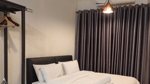 A neatly made bed with white linens, a dark headboard, and a hanging light fixture. - KLIA AIRPORT HOMESTAY 7 (Sepang)