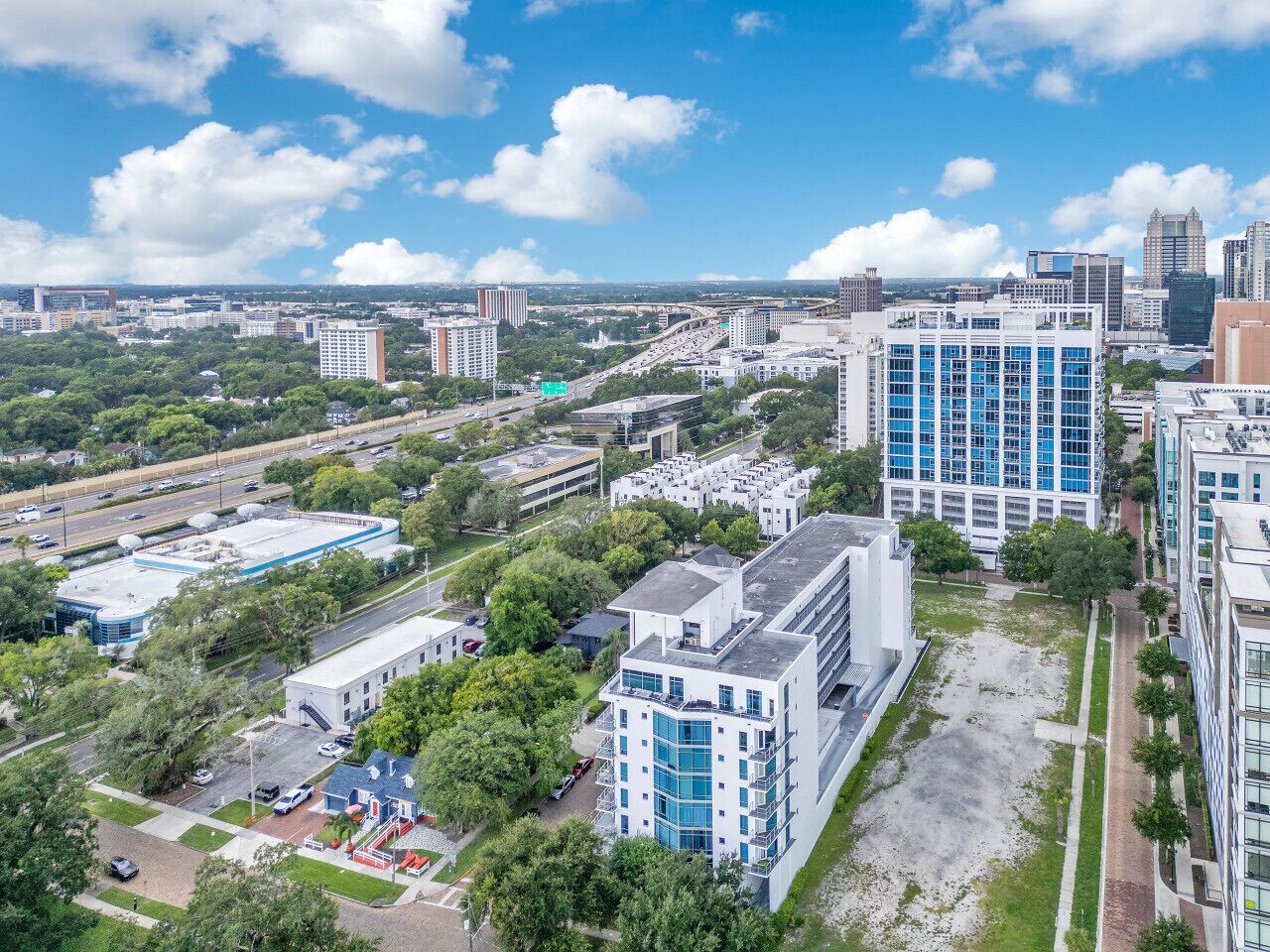 Vista aérea de un paisaje urbano con edificios modernos, calles y áreas verdes.