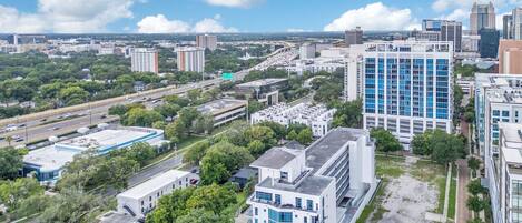 Vista aérea de un paisaje urbano con edificios modernos, calles y áreas verdes.