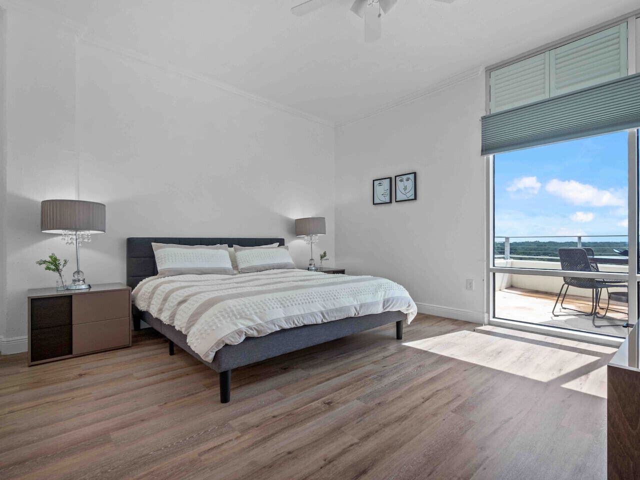 Une chambre à coucher avec un lit, des tables de chevet et une vue sur l’extérieur.