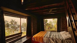 A bedroom with a bed, a bench, and a window overlooking greenery. - Misty Hogans Hill Station Stay | Entire Stay Near Munnar | Sleeps 10 (Kambilikandam)