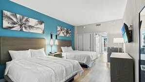 A hotel room with two beds, a nightstand, a lamp, and artwork on the walls. - Breakers 372-Oceanfront 1BR - Close to Boardwalk (Myrtle Beach)
