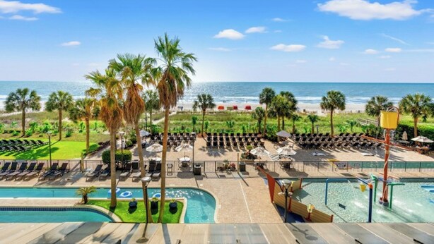 A resort with a pool area, lounge chairs, and a view of the beach and ocean. - Breakers 372-Oceanfront 1BR - Close to Boardwalk (Myrtle Beach)
