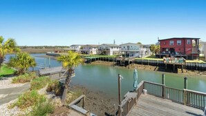 A waterfront property with a dock, a red building, and several white houses. - The Reagan- 4BR Channel House-Hot Tub (North Myrtle Beach)