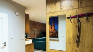 Un interior moderno con paneles de madera, un cuadro enmarcado y un sofá azul.