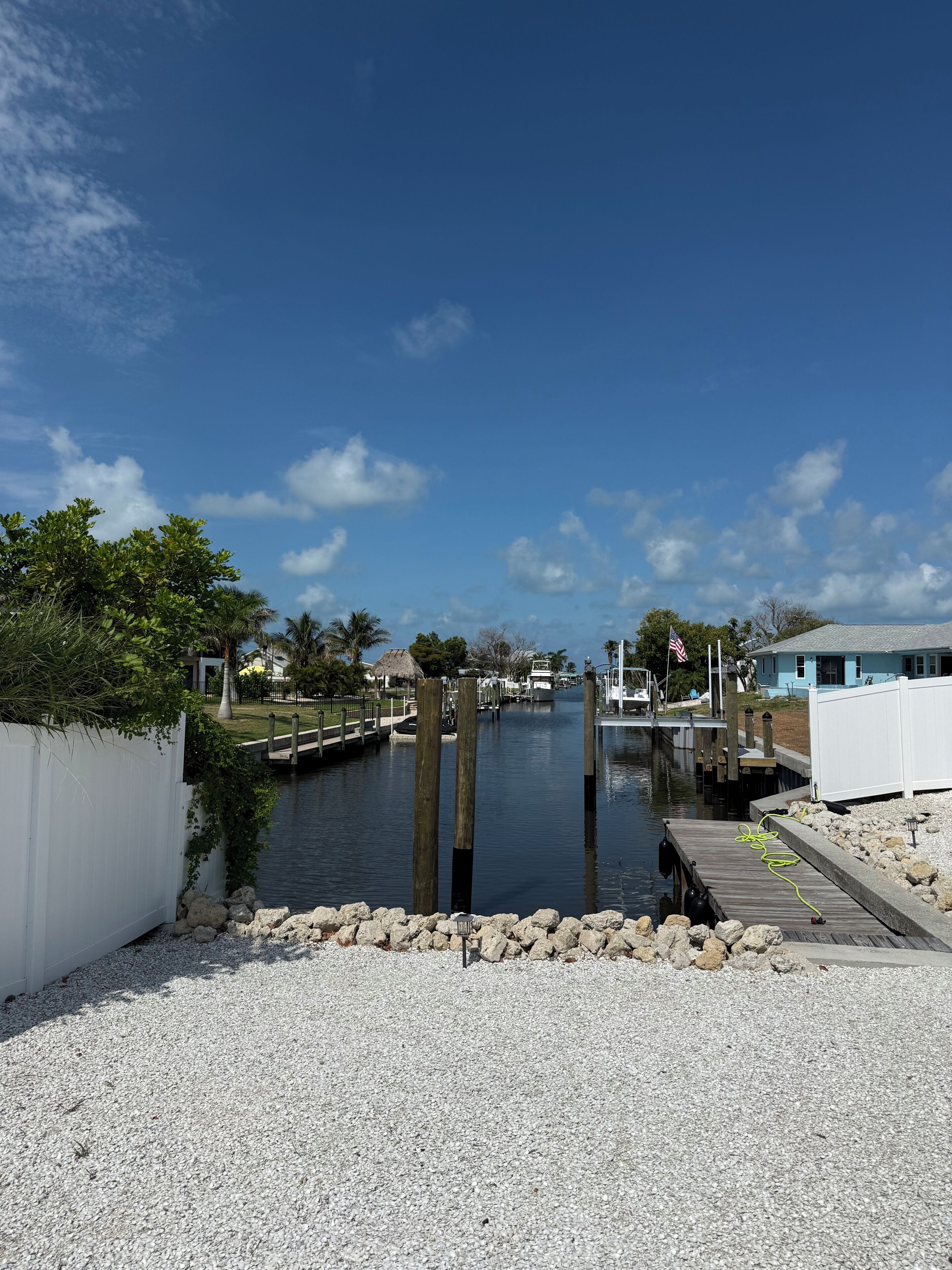 A marina with a dock, calm water, and a clear sky.