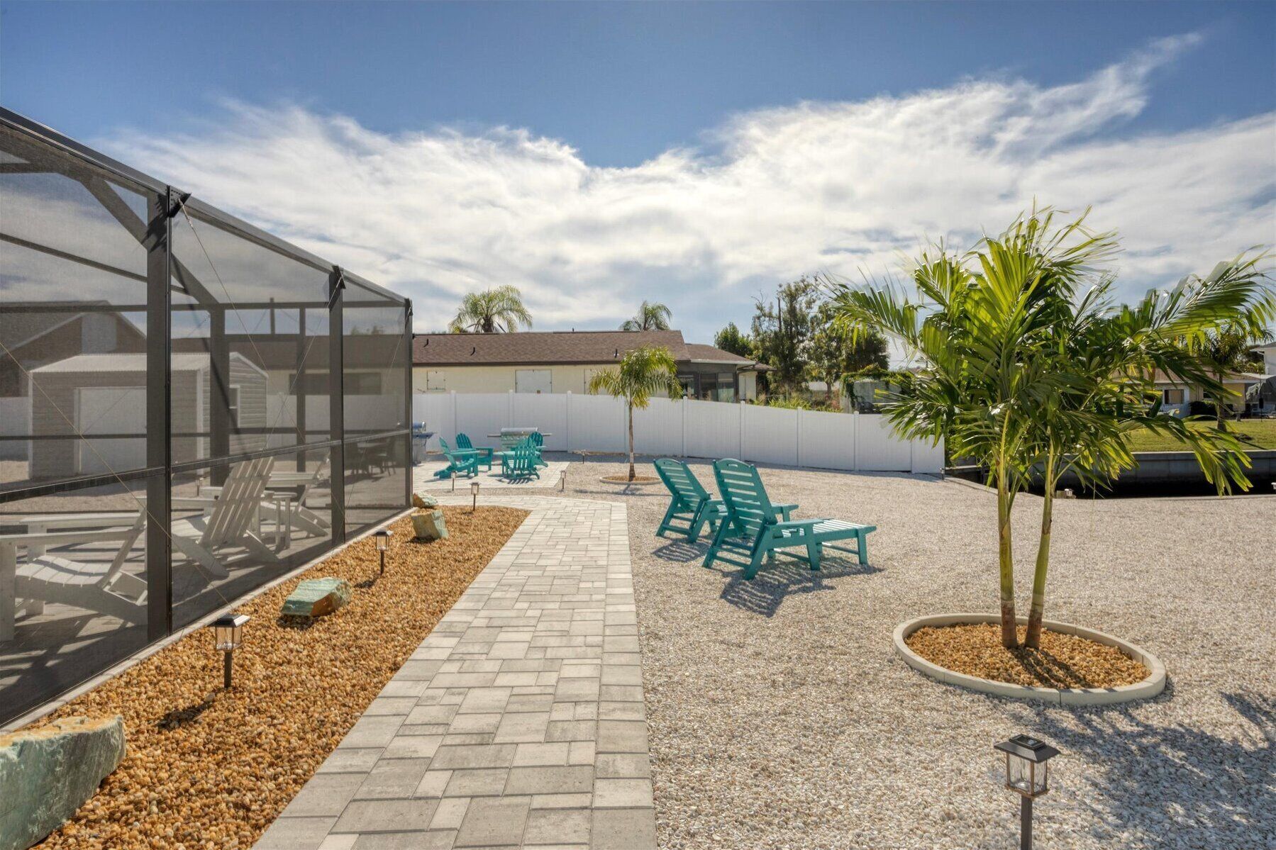 Un patio cubierto con mobiliario exterior y una pequeña palmera.