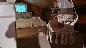 A cozy room with a bed, a hanging chair, and a small table. - Near Pullmann City - small house in the middle of nature... Vacation for the whole year... (Windorf)
