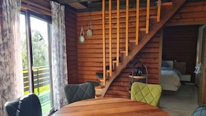 A wooden cabin interior with a dining table, chairs, a staircase, and a bed. - Near Pullmann City - small house in the middle of nature... Vacation for the whole year... (Windorf)