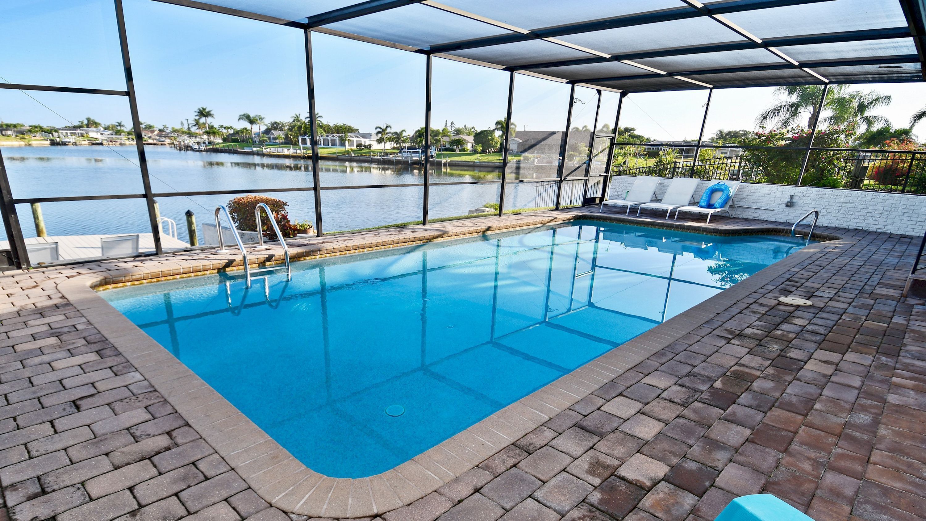 A swimming pool with a clear view of the lake and surrounding greenery.
