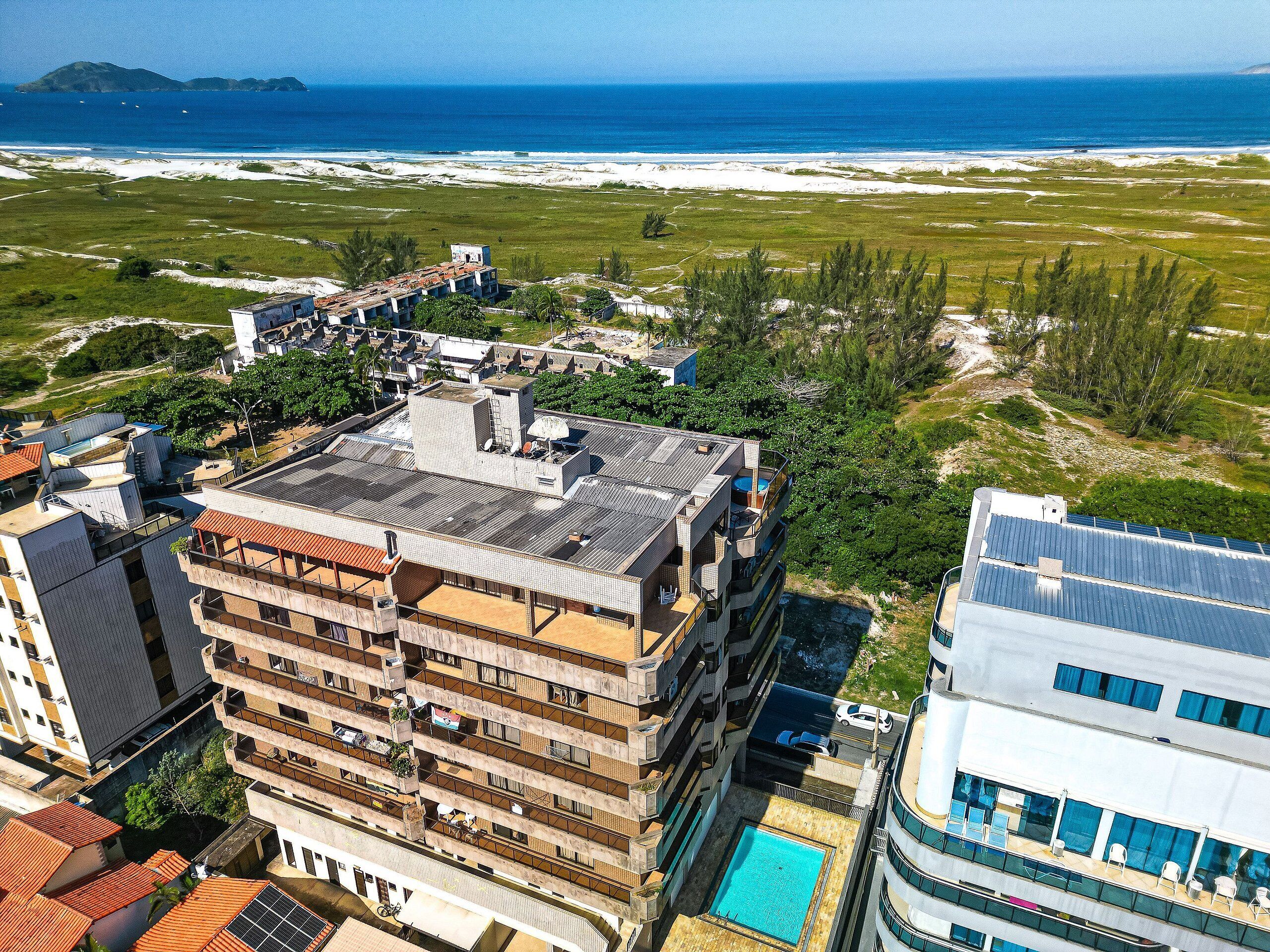 Un hôtel à plusieurs étages doté d’une piscine sur le toit et offrant une vue sur l’océan.